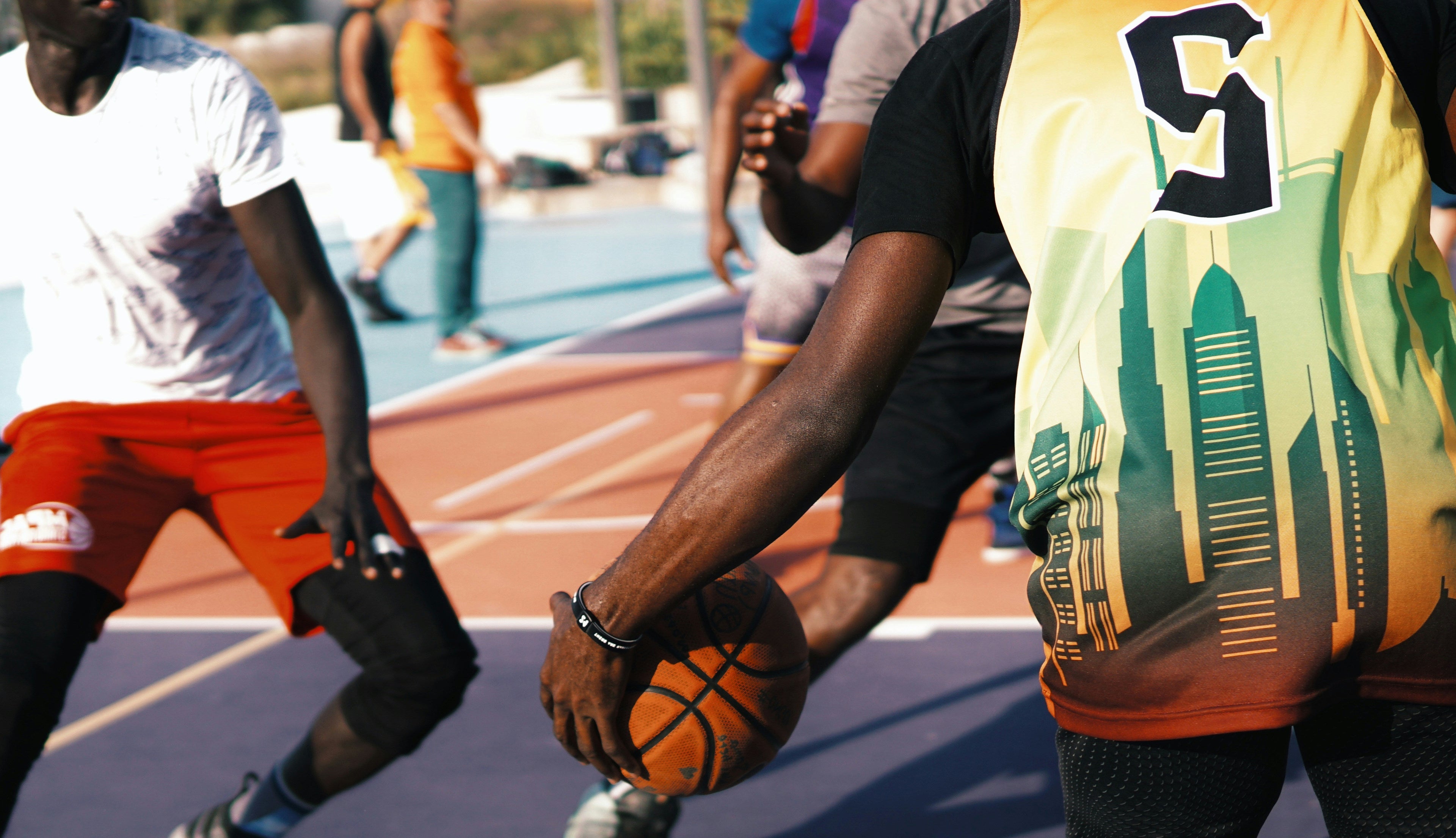 Basketball game in progress on an outdoor court with players in action.
